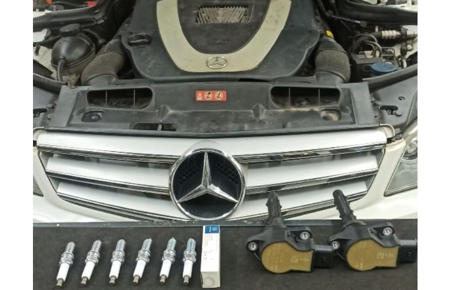 Mercedes-Benz engine with removed spark plugs and ignition coils displayed for misfire repair